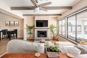 TV connectée, cheminée, livres, chaîne hi-fi