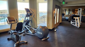 Ein Fitnessraum mit Cardiogeräten, Gewichtstrainern und Blick ins Freie.