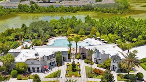 Zona residencial con piscina, jardines ajardinados y vistas de casas circundantes.