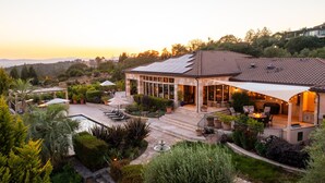 A house with a swimming pool, outdoor seating, and a patio area.