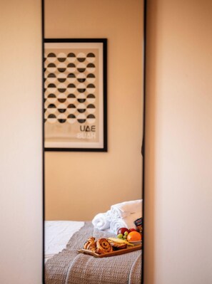 A hotel room with a bed, a tray of food, and a framed picture on the wall. - 3x Bedroom House (Sleeps 6x) (Warwickshire)