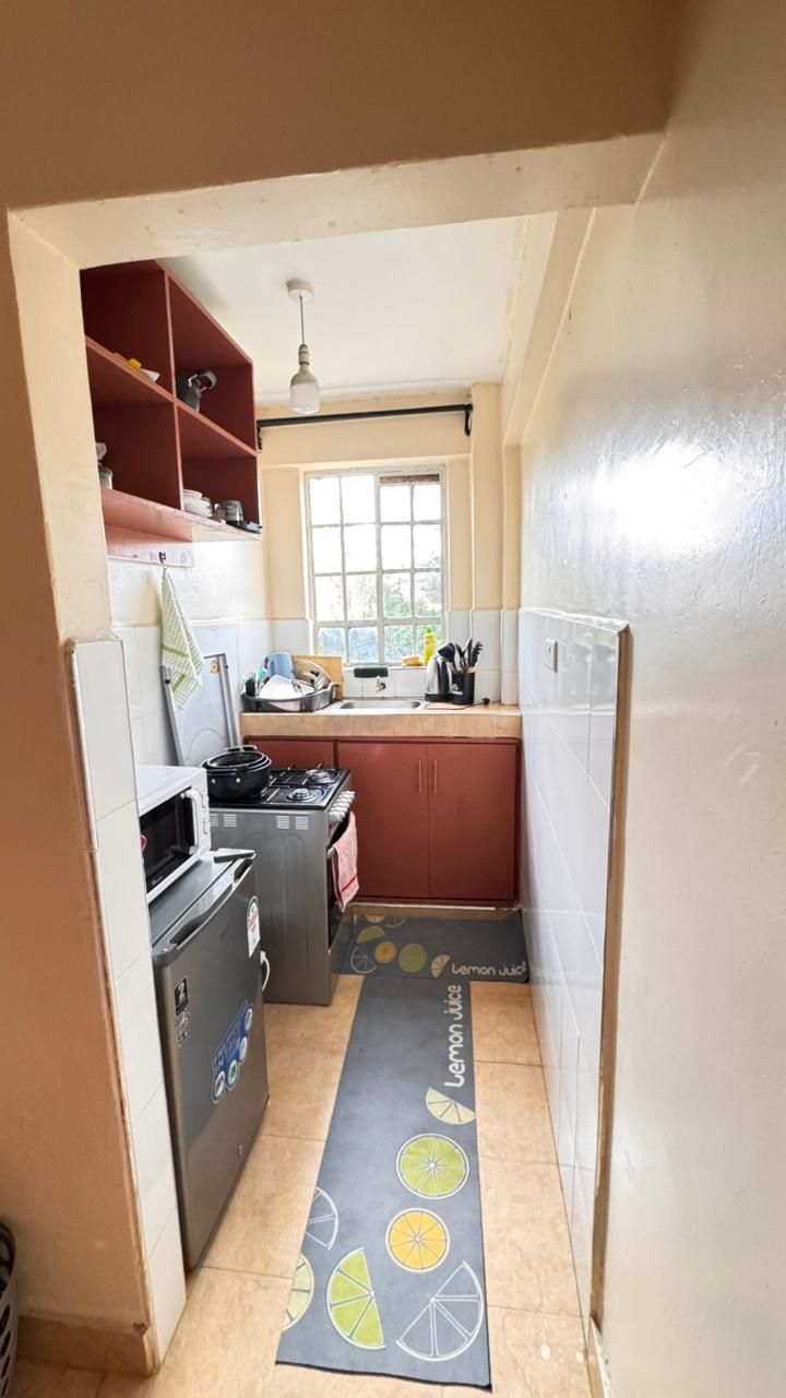 Una cocina compacta con microondas, estufa y lavamanos.