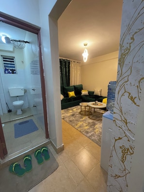Una sala de estar con un sofá, una mesa de centro y un dispensador de agua.