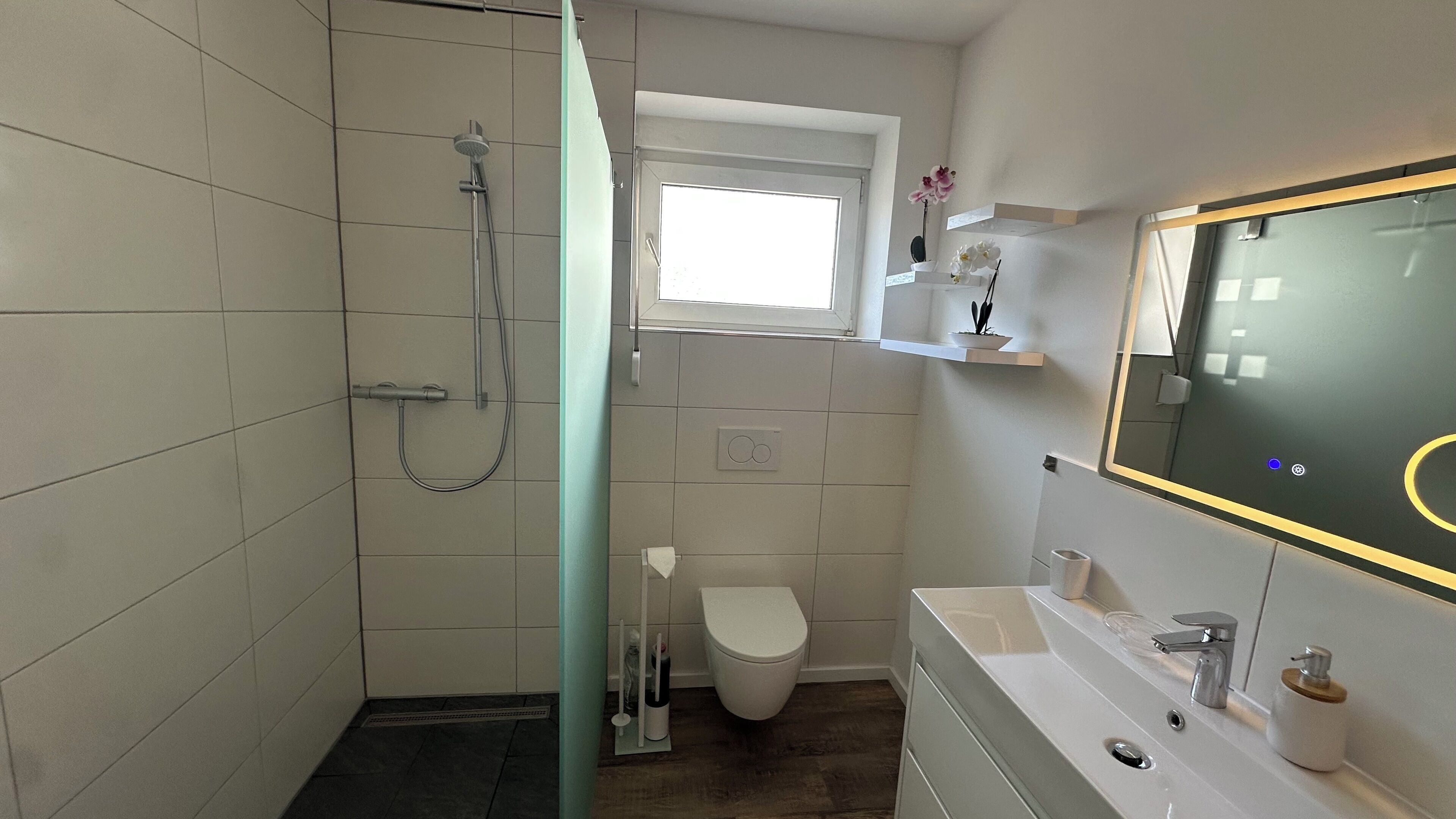 Une salle de bain avec douche, toilettes et lavabo.
