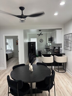 A modern kitchen with white cabinets, a black countertop, and a dining area with a round table and chairs. - stylish and spacious three-story getaway three bedrooms, two full baths. (cincinnati)