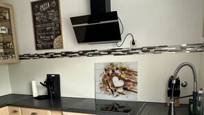 Eine moderne Küche mit einer schwarzen Dunstabzugshaube, einem Spülbecken und einer Arbeitsplatte.