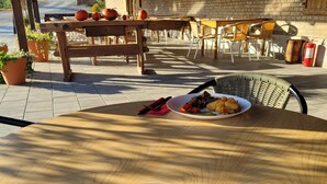 A dining table with a plate of food, a red napkin, and cutlery.