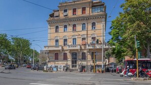 A multi-story building with a classic architectural style, featuring arched windows and a balcony on the second floor. - Perfectly located in the heart of Rome, transportation right outside your door (Roma)