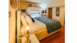 A bedroom with a bed, bedside table, lamp, and a wall-mounted shelf with decorative items. - Perfectly located in the heart of Rome, transportation right outside your door (Roma)