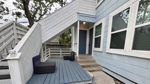 A house with a wooden deck, a staircase, and a door leading to the interior. - Charming duplex - convenient, comfortable, Close to It All. Beach, Work & Play! (Corpus Christi)