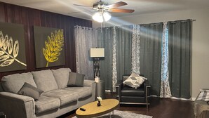 A living room with a sofa, coffee table, and a ceiling fan. - Charming duplex - convenient, comfortable, Close to It All. Beach, Work & Play! (Corpus Christi)
