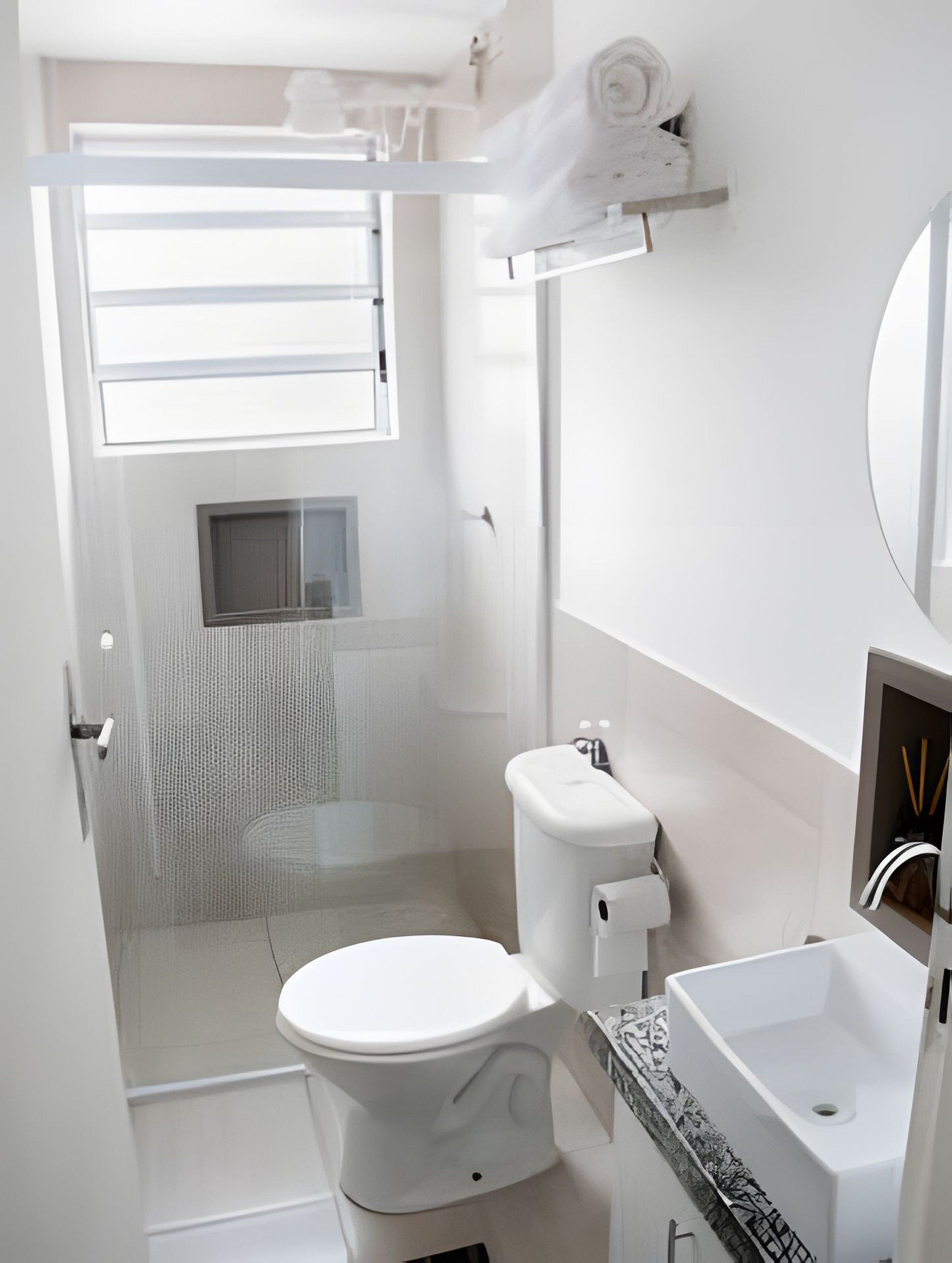 A modern bathroom with a toilet, sink, and shower.