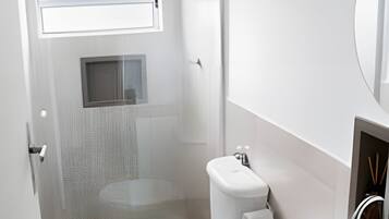 A modern bathroom with a toilet, sink, and shower.