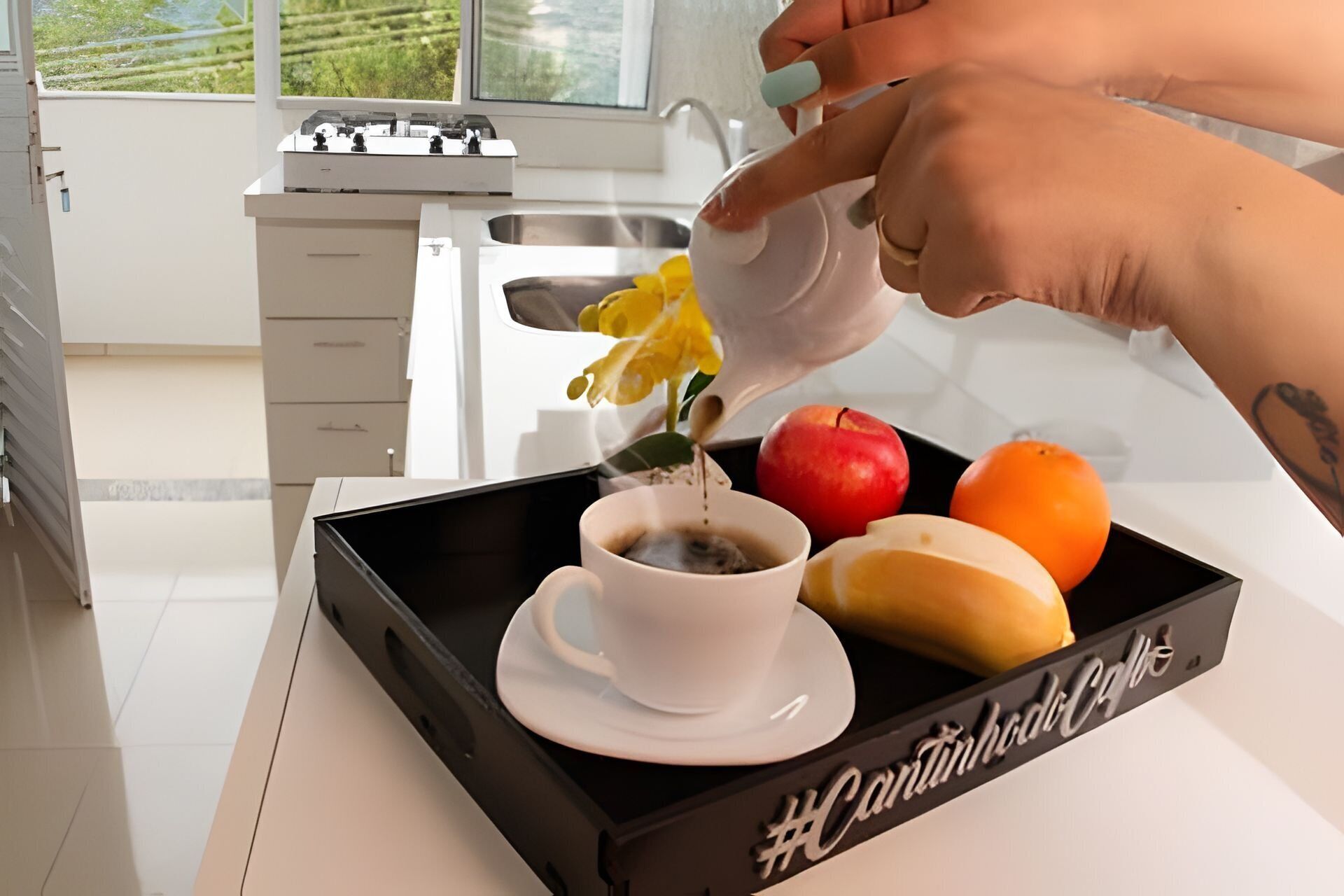 Un plateau avec une tasse de café, une pomme rouge, une orange et une banane.