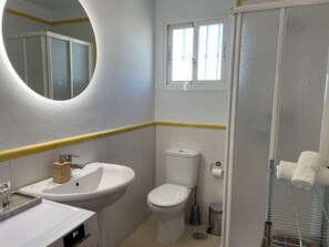 Un bagno con lavandino, WC e specchio.