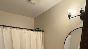Une salle de bain avec des toilettes, un lavabo et un rideau de douche.