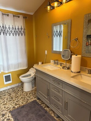 Un baño con inodoro, lavabo y espejo.