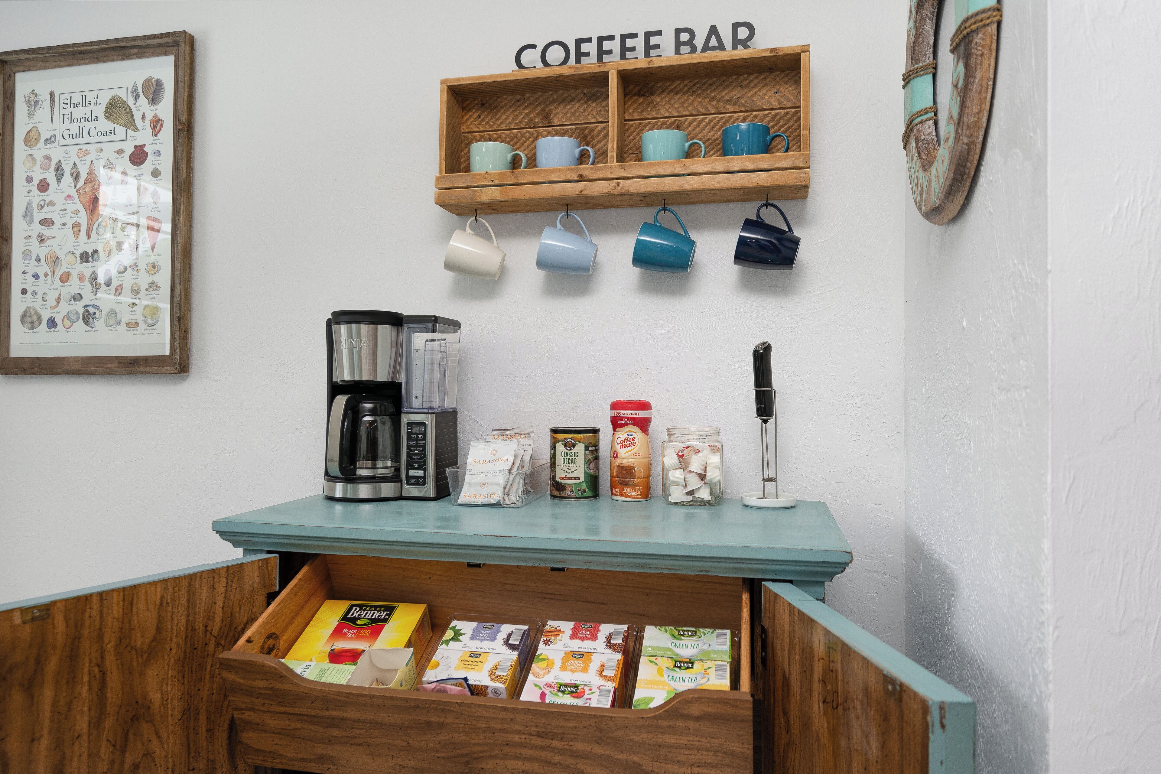 A coffee bar area with a coffee machine, mugs, and various coffee products.