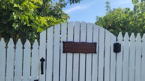 Una cerca blanca de piquetes con un letrero de madera que dice 'Frankie Manor Tiny Home'.