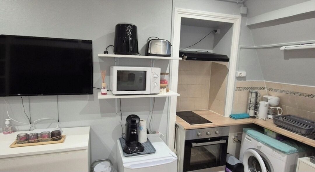 A compact kitchenette with a microwave, toaster, coffee maker, and a small oven.