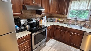 A kitchen with wooden cabinets, a stainless steel refrigerator, an oven, a microwave, and a sink. - Ryder Cup Rental, 1.4 miles away. 
3-bedroom apartment with parking (Farmingdale)