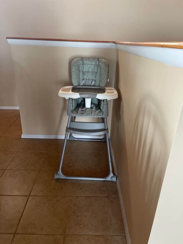 A corner of a room with a baby rocker.
