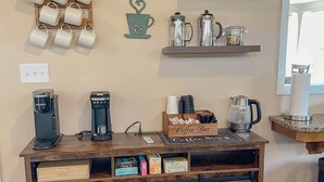 Une décoration sur le thème du café, avec des tasses, des machines à café et un panneau indiquant le bar à café.