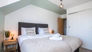 A modern bedroom with a bed, bedside tables, and a wardrobe. - in Bournemouth With 2 Bedrooms and 1 Bathrooms (Bournemouth)