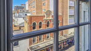 A view through a window of a building with a brick facade, arched windows, and a sign indicating the year 1887. - in Bournemouth With 2 Bedrooms and 1 Bathrooms (Bournemouth)