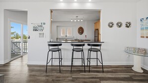 Une cuisine avec un coin bar, une vue sur l’extérieur et un mur décoratif.