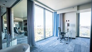 A modern hotel room with a large window, a bathtub, a desk, and a chair. - Beautiful Vegas Views, Luxury Condo in Las Vegas (Las Vegas)