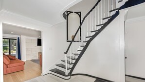 A modern interior with a curved staircase, a red sofa, and a view of the outdoors. - Spacious 4-bedroom house in Xenia near Universities (Xenia)