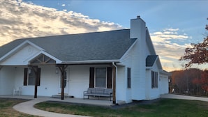 A two-story house with a front porch, a covered entryway, and a chimney.