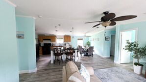 A spacious living room with a sofa and a dining area with chairs and a table. - 3-bedroom Private Forest Retreat Home with Wifi and Full Kitchen (Spring Hill)