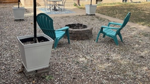 A house with a patio area featuring outdoor seating, a fire pit, and a pergola with string lights. - The Loyola – Warm & Welcoming Home Base for Your Pueblo Adventure (Pueblo)