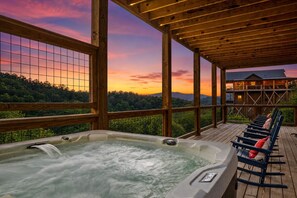 A wooden deck with a hot tub and lounge chairs, overlooking a forested landscape. - Available XMAS!! Amazing Views+Pool+Pickleball+Upgraded Arcade+Theater+Hot Tub (Sevierville)
