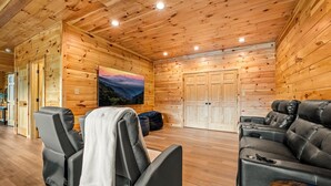 L’intérieur d’un chalet en bois comprend un fauteuil de massage, une table de massage et un canapé en cuir.