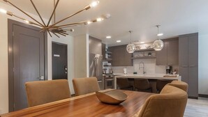 A modern kitchen with a central island, built-in appliances, and pendant lighting. - Bella's Mountain Vista | Prime Walk-to-Town 1BR Condo in Jackson Hole (Jackson)
