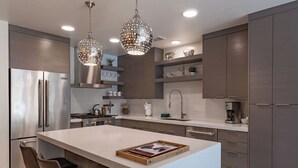 A modern kitchen with a central island, stainless steel appliances, and pendant lighting. - Bella's Mountain Vista | Prime Walk-to-Town 1BR Condo in Jackson Hole (Jackson)
