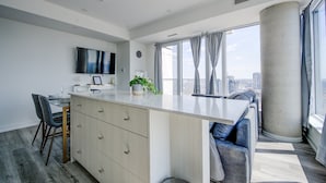 A modern kitchen with a large island, dining area, and a view of the city.