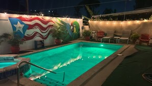 A swimming pool with a mural, lounge chairs, and potted plants. - Exclusive Tropical Oasis: Complete Privacy, Pool, and 24/7 Solar Power (Carolina)