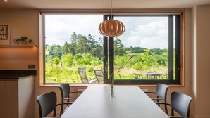 Un espace repas avec une grande fenêtre, une table et des chaises.