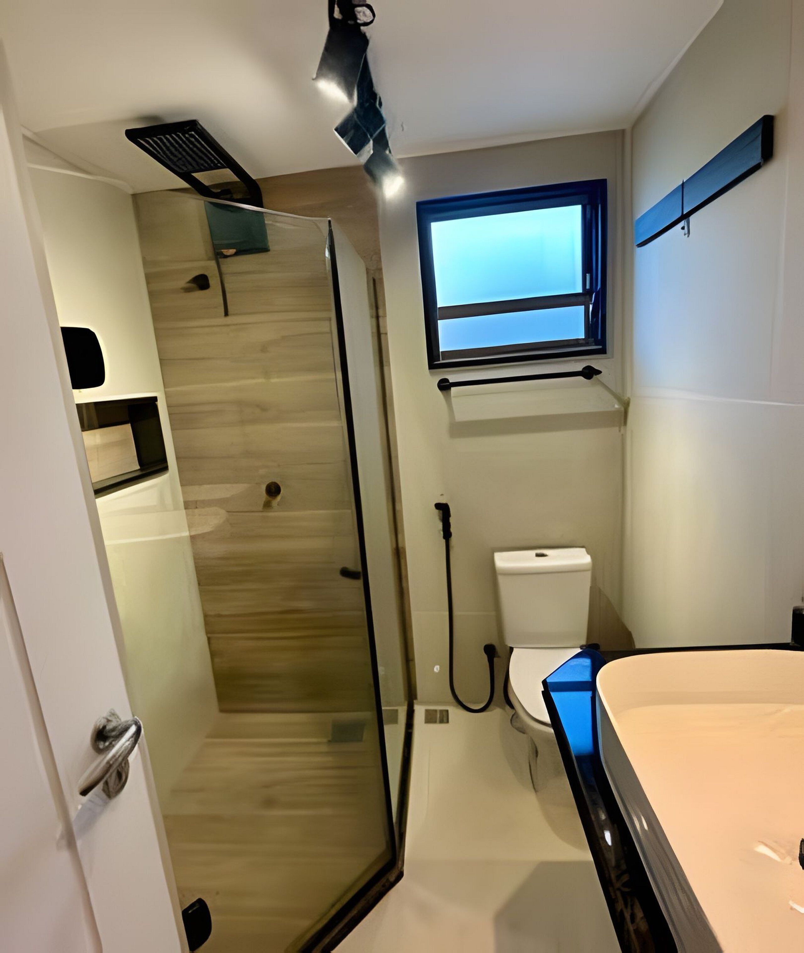 Une salle de bain moderne avec une douche à parois de verre, des toilettes et un lavabo.