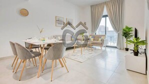 A modern living room with a dining area, a sofa, and a TV.