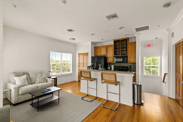 A modern kitchen with wooden cabinets, a stainless steel refrigerator, and a built-in microwave.