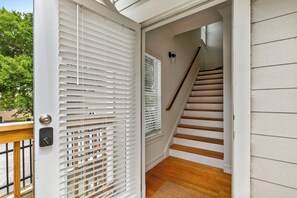 A staircase with white railings and a wooden floor leading to an upper level.