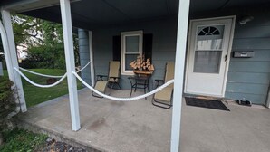 A covered porch with a ship model, two chairs, and a mailbox. - Cozy and Serene 2-bedroom pet friendly house with AC in Downtown Lorain (Lorain)
