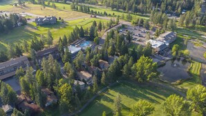 An aerial view of a residential area with multiple houses, a swimming pool, and a golf course.