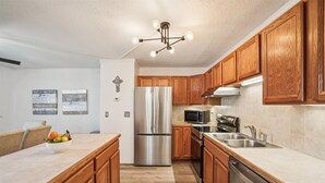 Una cocina moderna con armarios de madera, electrodomésticos de acero inoxidable y una isla central con fruta.