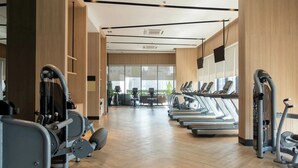 A gym with treadmills, weight machines, and exercise balls.